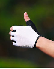 White cycling glove with black accents on a blurred green background