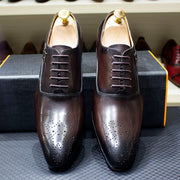 Pair of brown leather dress shoes on a textured surface with blurred background