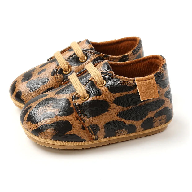 Pair of leopard print baby shoes on a white background