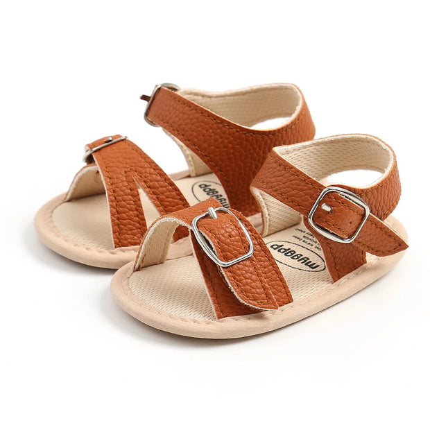 Pair of brown and beige sandals with buckles on a white background