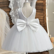 White dress with a large bow on a mannequin against a neutral background
