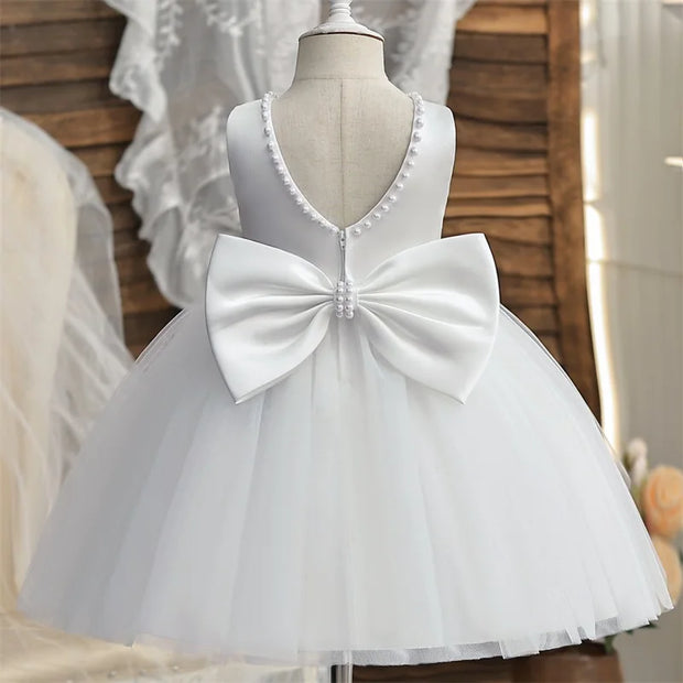 White dress with a large bow on a mannequin against a neutral background