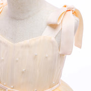 Mannequin wearing a light-colored dress with pearl embellishments on a white background