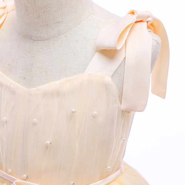 Mannequin wearing a light-colored dress with pearl embellishments on a white background