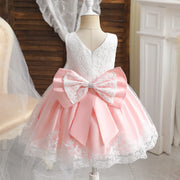 Pink and white lace dress with a large bow on a mannequin.