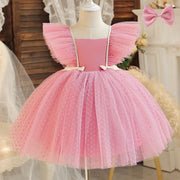 Pink tulle dress on a mannequin with a decorative bow in a soft focus background