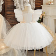 White tulle dress on a mannequin with a decorative background