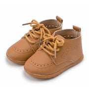 Pair of brown children's shoes with yellow laces on a white background