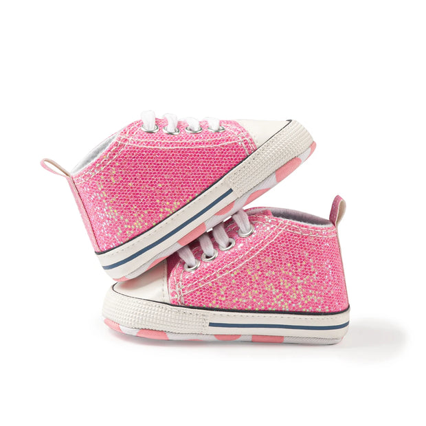 Pair of pink glittery high-top sneakers on a white background