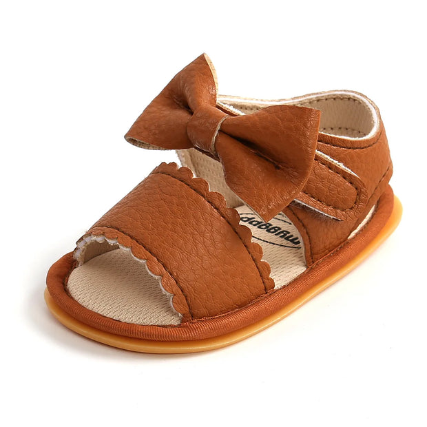 Brown baby sandal with a bow on a white background