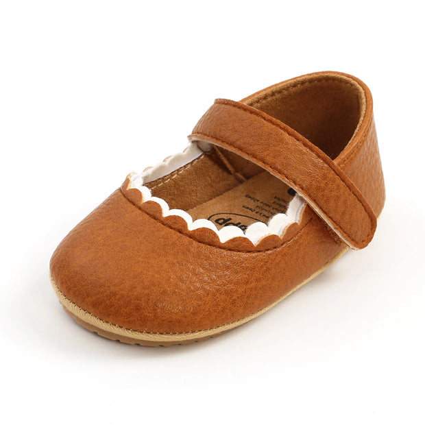 Brown baby shoe with a strap on a white background