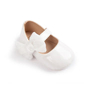 White baby shoe with a bow on a white background