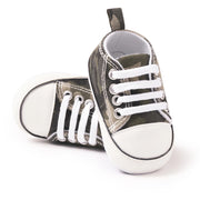 Pair of camouflage-patterned baby sneakers with white laces on a white background