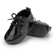 Pair of black patent leather shoes on a white background