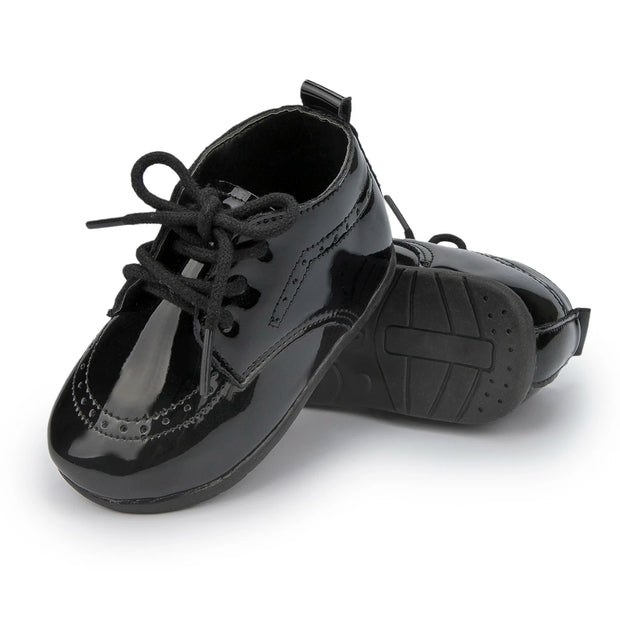 Pair of black patent leather shoes on a white background