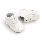 White baby shoes with gray soles on a white background