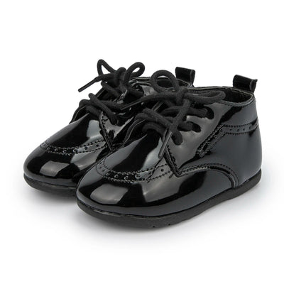 Pair of black patent leather shoes with laces on a white background