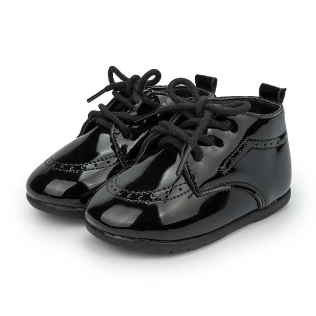 Pair of black patent leather shoes with laces on a white background