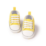 Pair of yellow baby sneakers on a white background