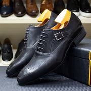 Black dress shoes with yellow soles on a shoe rack.