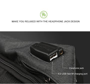 Close-up of a backpack with a headphone jack and USB charging port on a gray background.