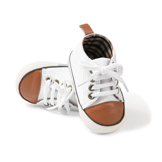 White sneakers with brown soles on a white background