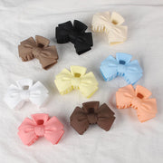 Assorted colorful hair bows on a textured white background