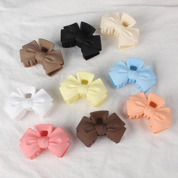 Assorted colorful hair bows on a textured white background
