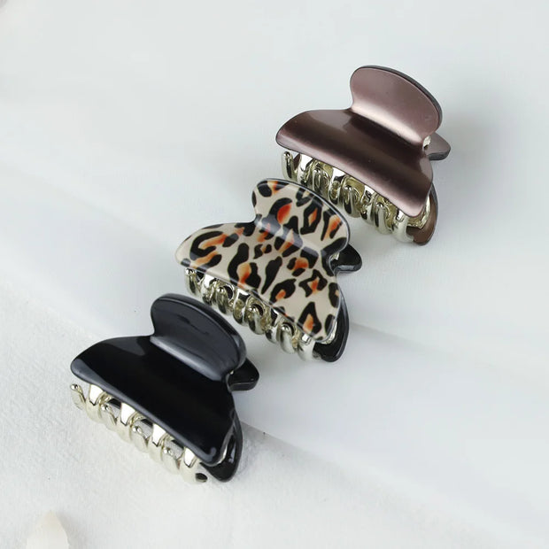 Three hair clips with different designs on a light background