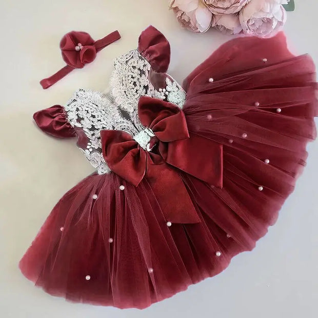 Maroon dress with silver embellishments and matching headband on a light background