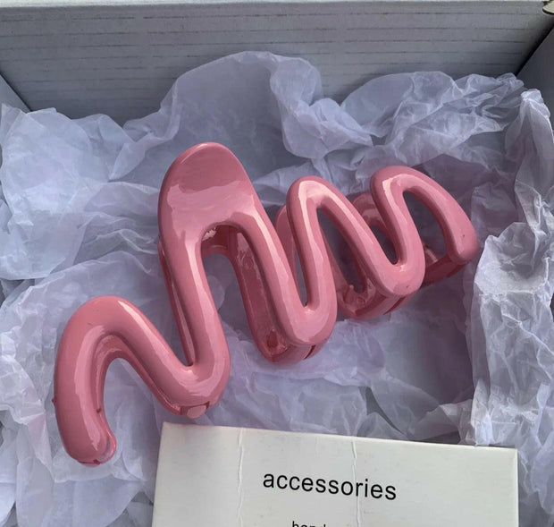 Pink hair accessory on white tissue paper with 'accessories' label.