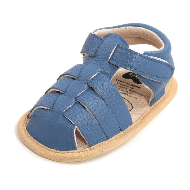 Blue baby sandal with beige sole on a white background