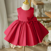 Red dress with a large bow on a mannequin against a blurred indoor background