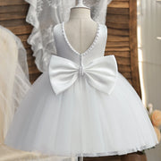 White dress with a large bow on a mannequin against a neutral background