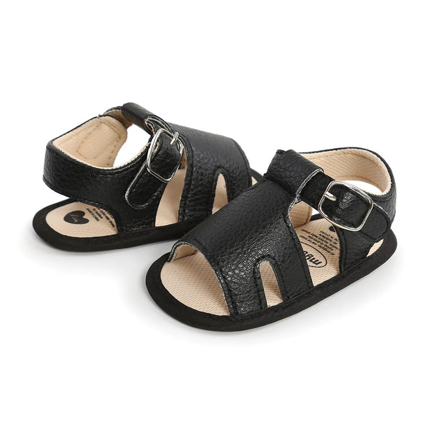Pair of black children's sandals with buckles on a white background