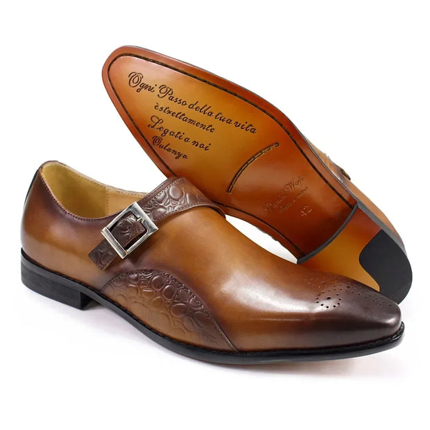 Brown leather shoes with embossed design and buckle on a white background