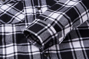Close-up of a black and white plaid shirt with rolled-up sleeve