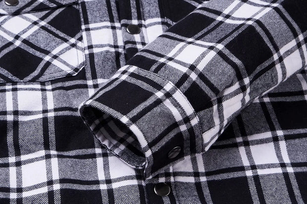 Close-up of a black and white plaid shirt with rolled-up sleeve
