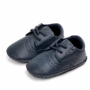Pair of navy blue baby shoes on a white background