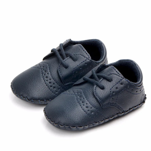 Pair of navy blue baby shoes on a white background