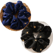 Two scrunchies, one blue and one black, with star patterns on a white background.