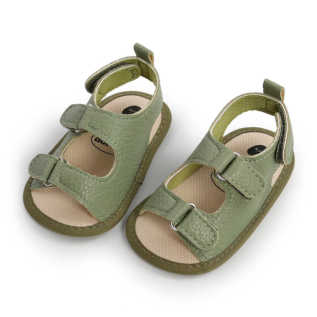 Pair of green baby sandals on a white background