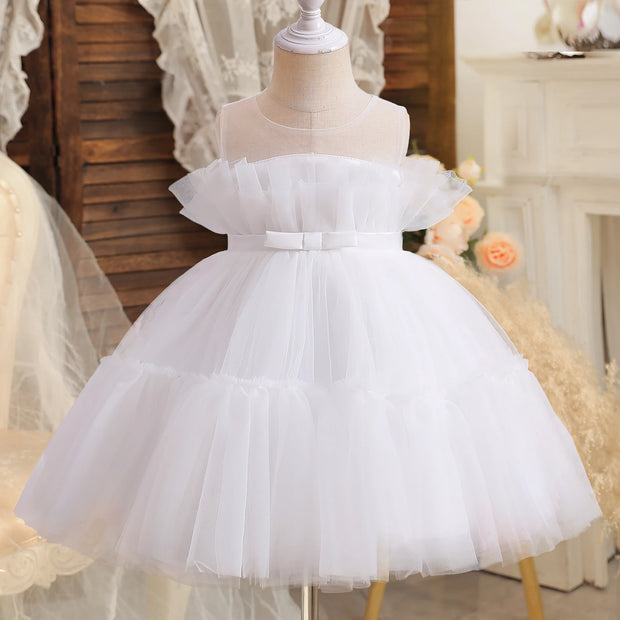 White tulle dress on a mannequin with a blurred decorative background