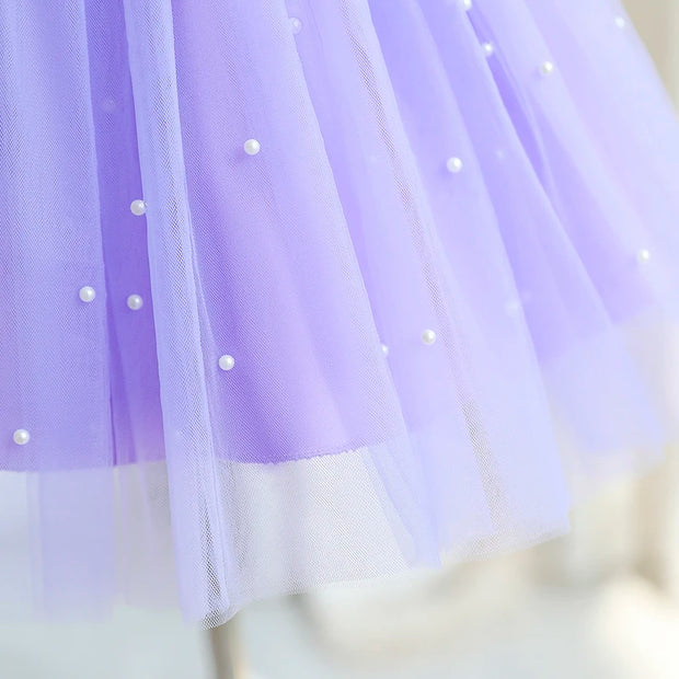 Close-up of a purple tulle fabric with small pearls, blurred background