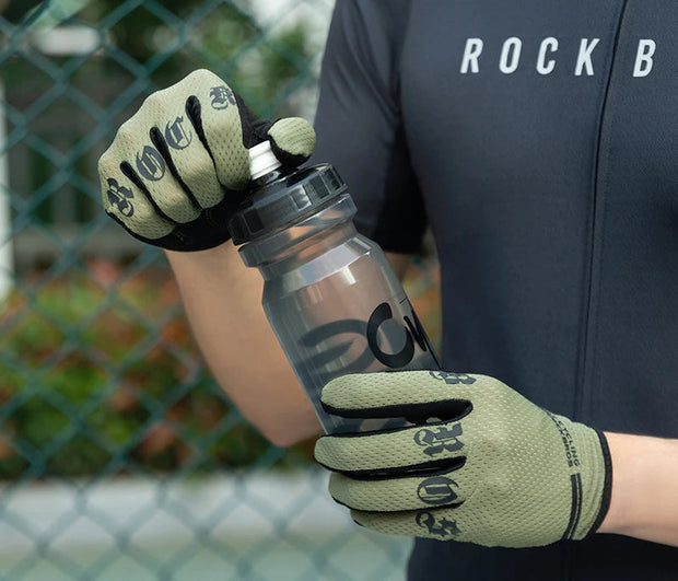 Person wearing gloves and a dark shirt, holding a clear water bottle.