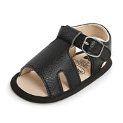 Black sandal with a buckle on a white background