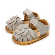 Pair of baby sandals with floral designs on a white background