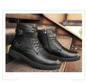Pair of black leather boots on a wooden surface