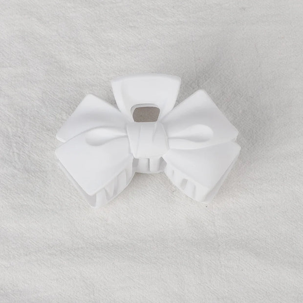 White bow-shaped object on a textured gray background