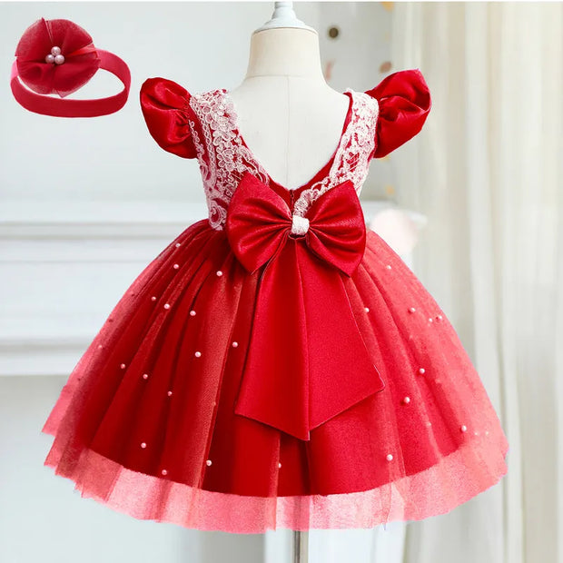 Red children's dress with a large bow and matching headband on a mannequin against a white background.